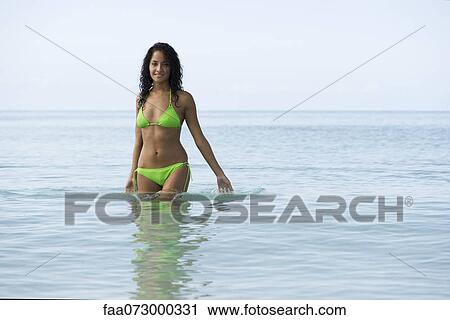 Young woman standing waist deep in water, portrait View Large Photo Image Stock Image - Young woman standing waist deep in water, portrait. Fotosearch