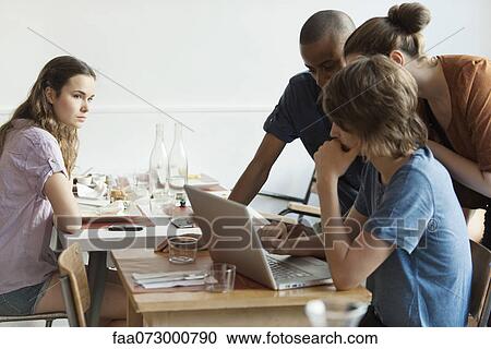 Young woman watching friends using laptop computer View Large Photo Image Stock Image - Young woman watching friends using laptop computer. Fotosearch