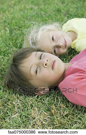 Boy and girl lying on grass, portrait View Large Photo Image Stock Photograph - Boy and girl lying on grass, portrait. Fotosearch