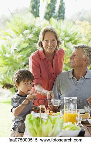 Stock Photography - Boy and grandparents having meal outdoors. Fotosearch
