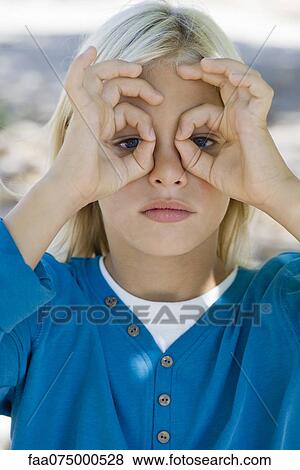 Boy forming circles with fingers around eyes View Large Photo Image Stock Photo - Boy forming circles with fingers around eyes. Fotosearch