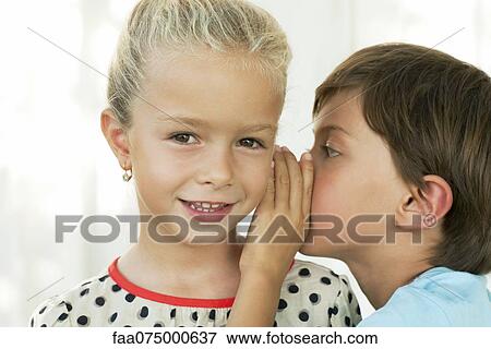 Boy whispering in girl's ear View Large Photo Image Stock Photo - Boy whispering in girl's ear. Fotosearch
