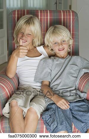 Brothers sitting in armchair, portrait View Large Photo Image Stock Image - Brothers sitting in armchair, portrait. Fotosearch