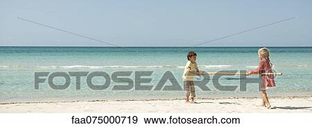 Children carrying bamboo together at the beach View Large Photo Image Stock Photo - Children carrying bamboo together at the beach. Fotosearch