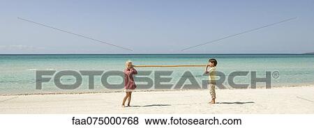 Children talking to each other through bamboo at the beach View Large Photo Image Stock Photo - Children talking to each other through bamboo at the beach. Fotosearch