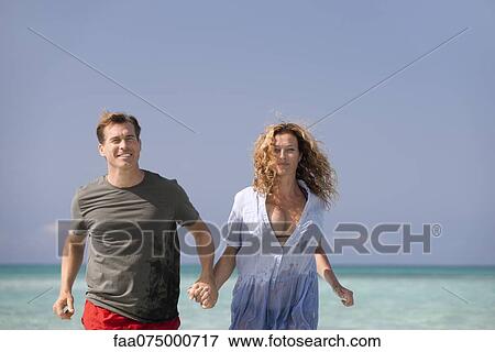 Couple at beach, holding hands View Large Photo Image Stock Photo - Couple at beach, holding hands. Fotosearch