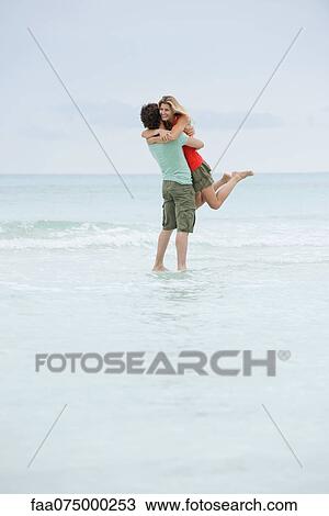 Couple embracing at the beach View Large Photo Image Stock Image - Couple embracing at the beach. Fotosearch