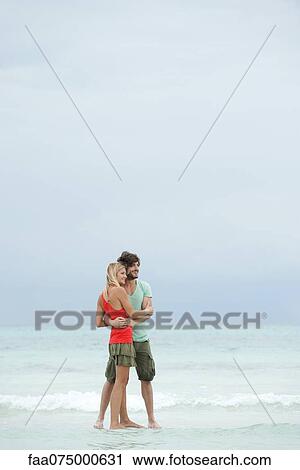 Couple embracing at the beach View Large Photo Image Stock Image - Couple embracing at the beach. Fotosearch