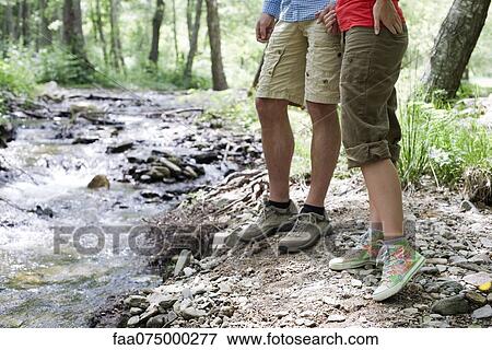 Couple hiking along stream in woods, low section View Large Photo Image Stock Photo - Couple hiking along stream in woods, low section. Fotosearch