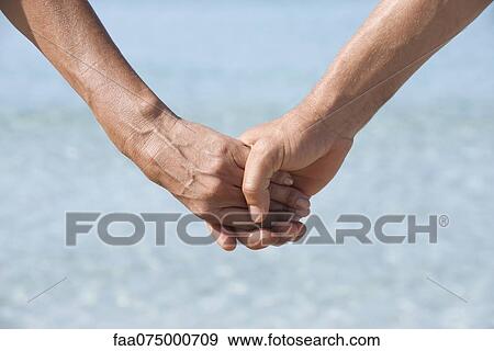Couple holding hands, cropped View Large Photo Image Stock Photo - Couple holding hands, cropped. Fotosearch
