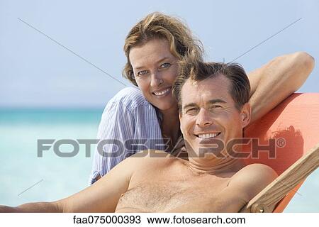 Stock Image - Couple spending time at beach, portrait. Fotosearch