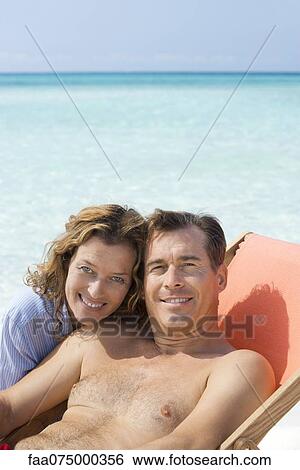 Stock Photograph - Couple spending time at beach, portrait. Fotosearch