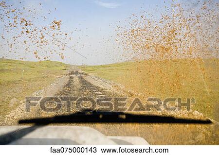 Stock Image - Dirt road viewed through muddy car windshield. Fotosearch