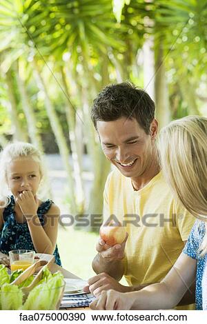 Family having meal outdoors, focus on one man View Large Photo Image Stock Image - Family having meal outdoors, focus on one man. Fotosearch