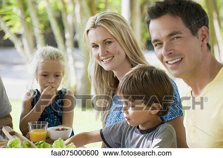 Family having meal outdoors, focus on young woman View Large Photo Image Stock Image - Family having meal outdoors, focus on young woman. Fotosearch
