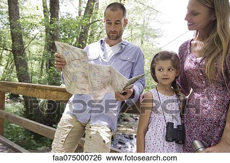 Stock Photograph - Family pausing in woods to consult map. Fotosearch