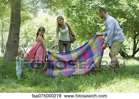 Family preparing for picnic in meadow View Large Photo Image Stock Photo - Family preparing for picnic in meadow. Fotosearch