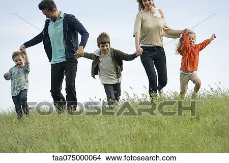 Family running hand in hand in field View Large Photo Image Picture - Family running hand in hand in field. Fotosearch