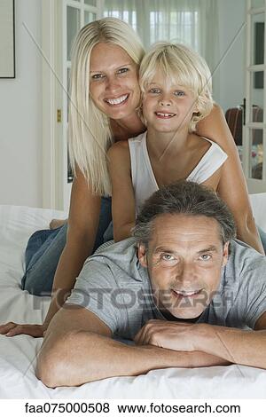 Stock Photo - Family with one child, portrait. Fotosearch