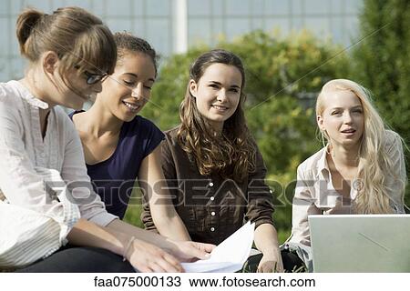 Female university students studying together outdoors, focus on two women View Large Photo Image Stock Image - Female university students studying together outdoors, focus on two women. Fotosearch