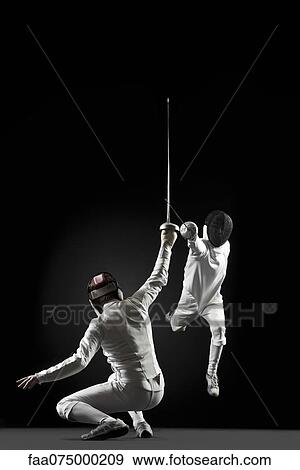 Fencers fencing, one fencer jumping in air View Large Photo Image Stock Photo - Fencers fencing, one fencer jumping in air. Fotosearch