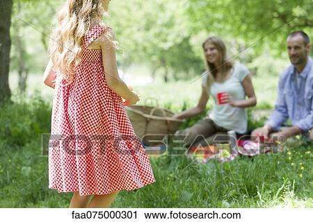 Girl having picnic with parents outdoors, rear view View Large Photo Image Stock Image - Girl having picnic with parents outdoors, rear view. Fotosearch