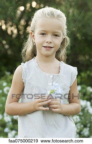 Stock Photo - Girl holding flowers, portrait. Fotosearch