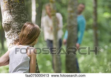 Girl playing hide and seek with parents in woods, rear view View Large Photo Image Stock Image - Girl playing hide and seek with parents in woods, rear view. Fotosearch