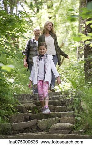 Girl walking down stone steps in woods, parents in background View Large Photo Image Stock Photograph - Girl walking down stone steps in woods, parents in background. Fotosearch
