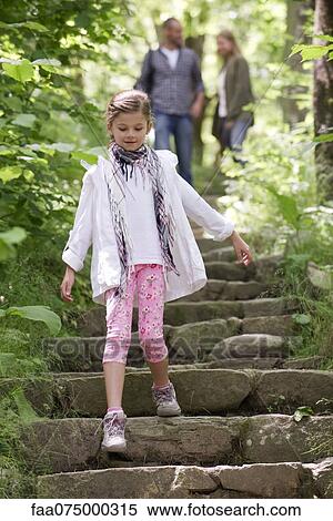 Girl walking down stone steps in woods, parents in background View Large Photo Image Stock Photography - Girl walking down stone steps in woods, parents in background. Fotosearch