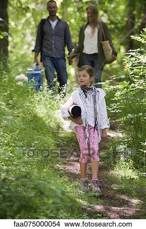 Girl walking in woods, parents in background View Large Photo Image Picture - Girl walking in woods, parents in background. Fotosearch
