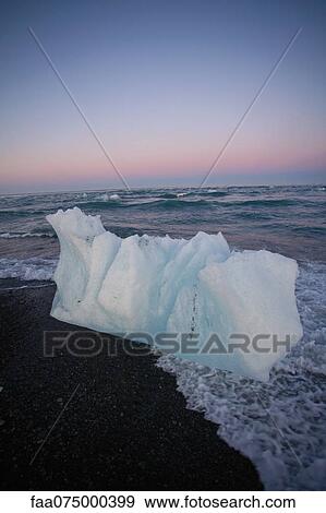 Large piece of glacial ice washed up on beach, Jokulsarlon glacial lagoon, Iceland View Large Photo Image Stock Photo - Large piece of glacial ice washed up on beach, Jokulsarlon glacial lagoon, Iceland. Fotosearch