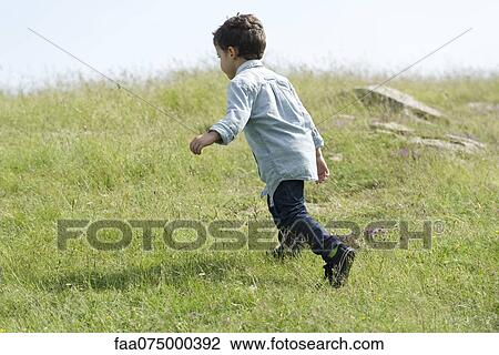 Little boy running in meadow, rear view View Large Photo Image Stock Image - Little boy running in meadow, rear view. Fotosearch