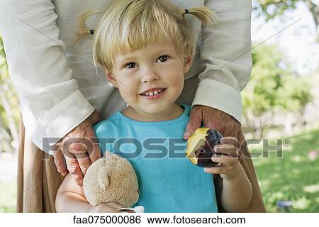 Little girl holding biten plum View Large Photo Image Stock Photograph - Little girl holding biten plum. Fotosearch