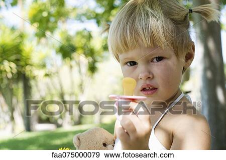 Little girl holding pacifier View Large Photo Image Stock Photo - Little girl holding pacifier. Fotosearch