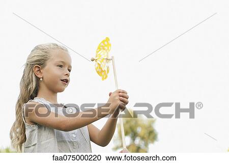 Stock Image - Little girl holding pinwheel. Fotosearch