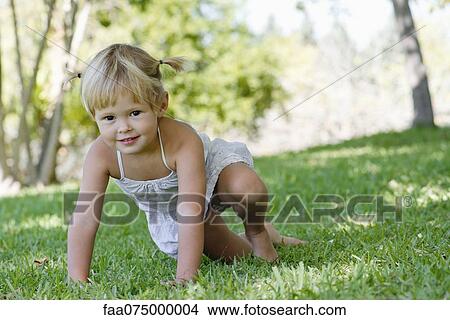 Picture - Little girl playing on grass. Fotosearch