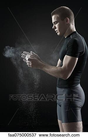 Male athlete applying chalk to hands View Large Photo Image Stock Photo - Male athlete applying chalk to hands. Fotosearch
