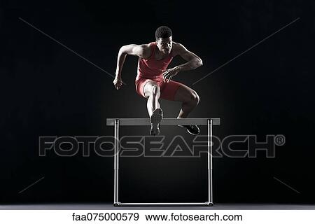 Male athlete clearing hurdle View Large Photo Image Stock Photo - Male athlete clearing hurdle. Fotosearch