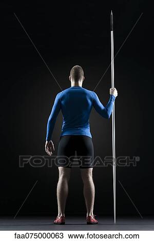 Male athlete standing with javelin, rear view View Large Photo Image Stock Image - Male athlete standing with javelin, rear view. Fotosearch