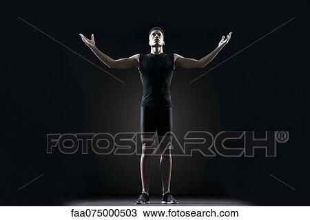 Stock Image - Male athlete with arms outstretched, portrait. Fotosearch