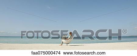 Man reading book at the beach View Large Photo Image Picture - Man reading book at the beach. Fotosearch