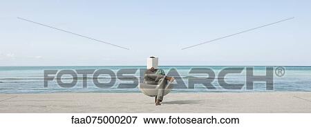 Stock Photo - Man reading book at the beach. Fotosearch
