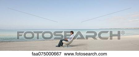 Man reading book at the beach View Large Photo Image Stock Photo - Man reading book at the beach. Fotosearch