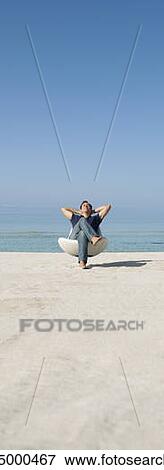 Stock Photo - Man relaxing in chair on beach. Fotosearch