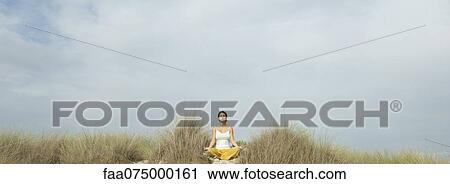 Mature woman meditating on beach View Large Photo Image Stock Image - Mature woman meditating on beach. Fotosearch