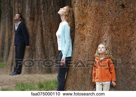 Mother and daughter leaning against tree trunk, breathing fresh air View Large Photo Image Stock Image - Mother and daughter leaning against tree trunk, breathing fresh air. Fotosearch