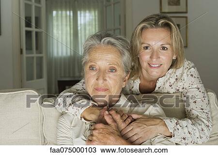 Stock Image - Mother and daughter spending time in living room. Fotosearch