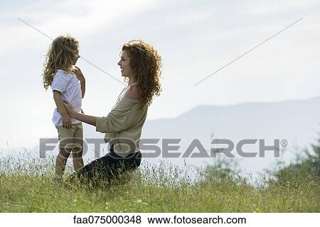 Mother and daughter together in meadow, side view View Large Photo Image Stock Photo - Mother and daughter together in meadow, side view. Fotosearch