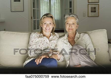 Mother and daughter watch TV in living room View Large Photo Image Stock Photo - Mother and daughter watch TV in living room. Fotosearch